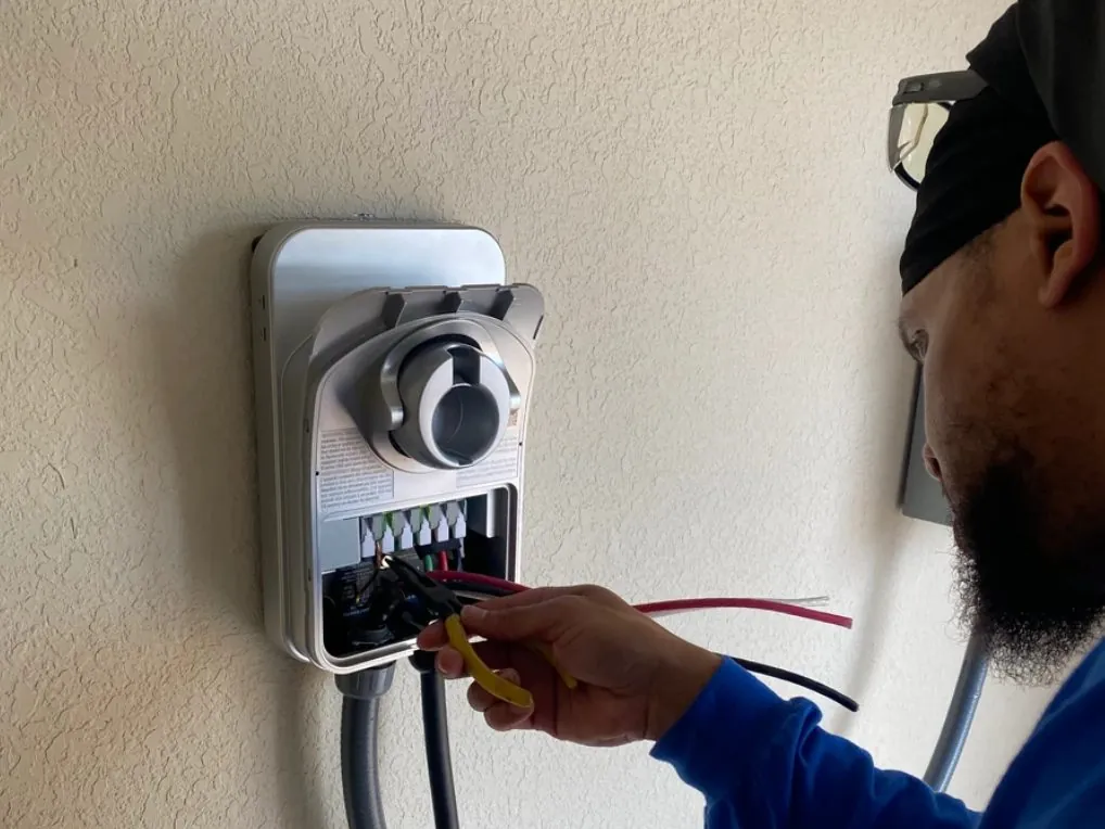 Sonshines electrician wiring a wall-mounted home EV charger